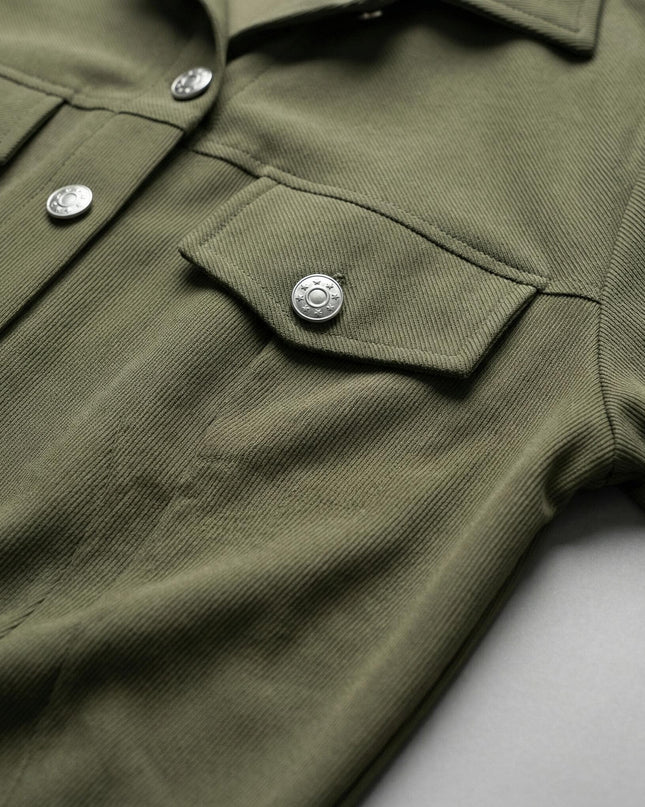 Κοντινή λεπτομέρεια από το χακί σακάκι του γυναικείου σετ plus size, που αναδεικνύει την ανάγλυφη υφή του υφάσματος, τα μεταλλικά κουμπιά και την τσέπη.