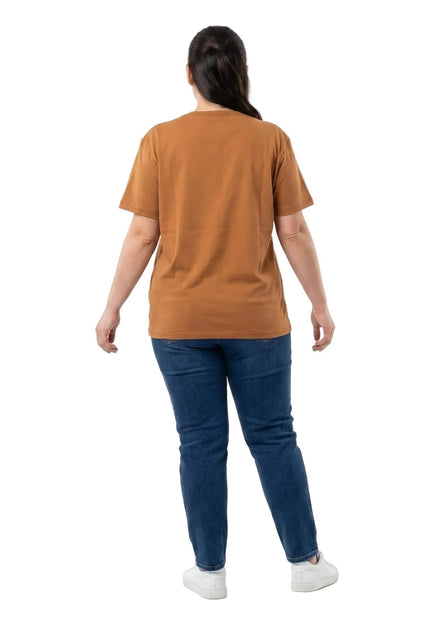 Γυναικείο βαμβακερό t-shirt σε ανοιχτό καφέ χρώμα και μεγάλα μεγέθη. Όψη από πίσω που δείχνει τη χαλαρή εφαρμογή του, φορεμένο με τζιν.
