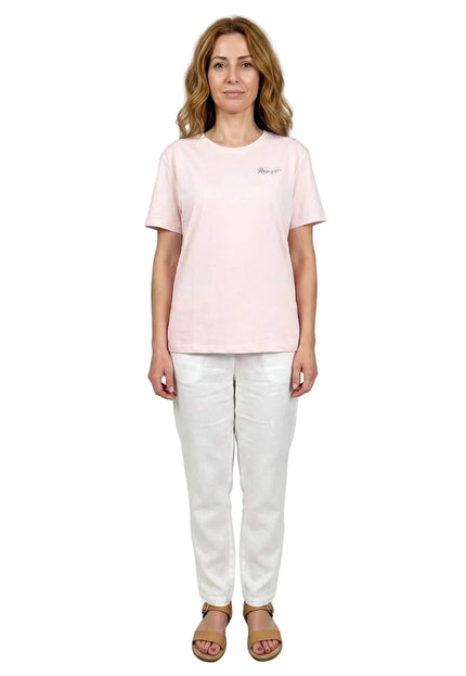 Ολόσωμη λήψη με ένα γυναικείο βαμβακερό t-shirt μεγάλα μεγέθη. Διαθέτει απαλό ροζ χρώμα, κοντά μανίκια και μια μικρή επιγραφή στο στήθος.
