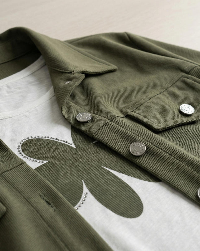 Κοντινή λεπτομέρεια από γυναικείο σετ plus size, με εστίαση στο χακί σακάκι με τα μεταλλικά κουμπιά και το λευκό t-shirt με τη διακοσμητική στάμπα.