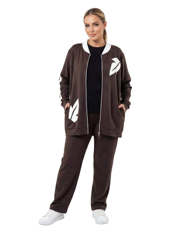 Καφέ γυναικείο σετ δύο τεμαχίων σε μεγάλα μεγέθη, σε ολόσωμη λήψη. Ζακέτα με λευκά σχέδια φύλλων και φερμουάρ, συνδυασμένη με άνετο παντελόνι.