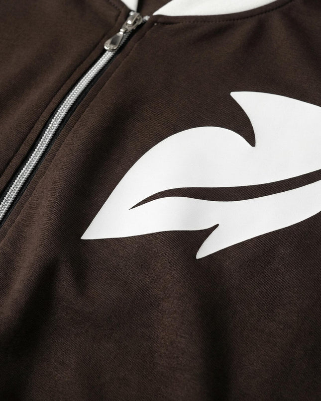 Κοντινή λεπτομέρεια υφάσματος από καφέ καθημερινό γυναικείο σετ σε μεγάλα μεγέθη, με ασημί φερμουάρ και λευκό διακοσμητικό σχέδιο στο στήθος.