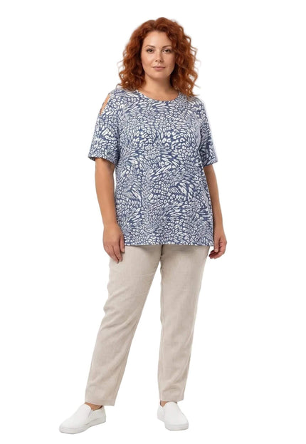 Ολόσωμη λήψη σε λευκό φόντο με plus size γυναικεία καλοκαιρινή τουνίκ με έξω ώμους σε μπλε-λευκό μοτίβο, συνδυασμένη με μπεζ παντελόνι.