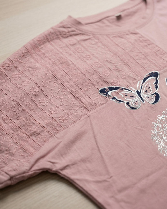 Κοντινή λεπτομέρεια σε καλοκαιρινή βαμβακερή τουνίκ μεγάλα μεγέθη. Διακρίνεται το απαλό ροζ χρώμα, το κεντημένο δίχτυ και οι όμορφες απλικέ πεταλούδες.