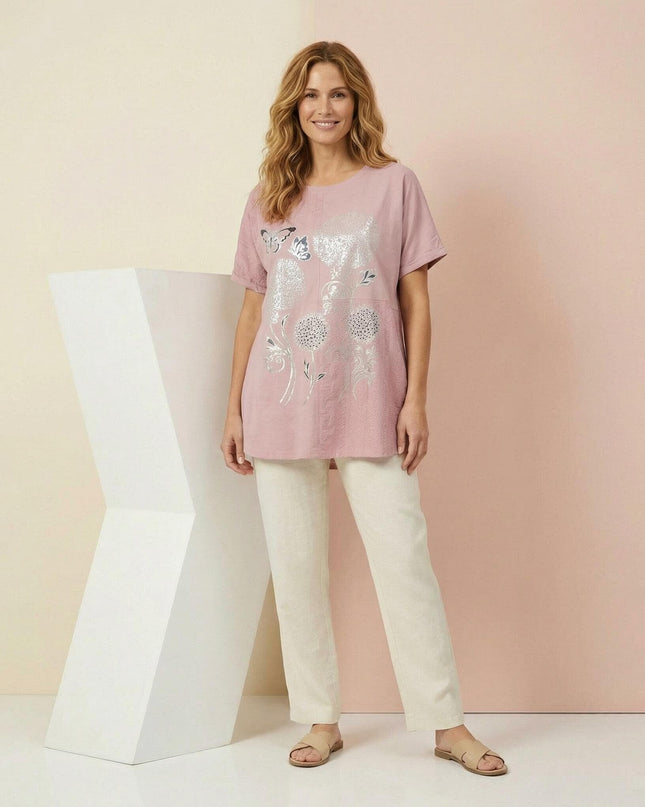 Ολόσωμη λήψη με γυναίκα να φοράει καλοκαιρινή βαμβακερή τουνίκ σε απαλό ροζ με εντυπωσιακό ασημί print, ιδανική για μεγάλα μεγέθη.