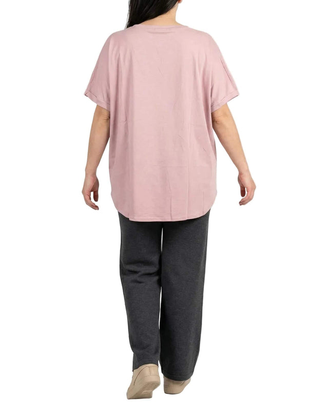 Πίσω όψη: Καλοκαιρινή βαμβακερή τουνίκ μεγάλα μεγέθη σε απαλό ροζ. Το μοντέλο σε λευκό φόντο αναδεικνύει την άνετη γραμμή και το καμπυλωτό στρίφωμα.