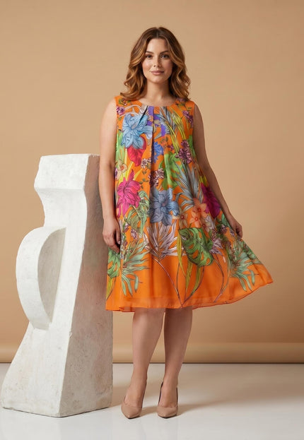 Ολόσωμη λήψη: Καλοκαιρινό φόρεμα plus size σε γραμμή Α, σε έντονο πορτοκαλί χρώμα με εντυπωσιακό τροπικό floral print και φαρδιές τιράντες.