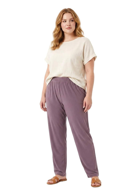 Ολόσωμη λήψη σε λευκό φόντο με plus size μοντέλο που φοράει καλοκαιρινό γυναικείο παντελόνι με λάστιχο σε μοβ-λιλά χρώμα.