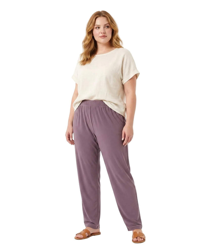 Ολόσωμη λήψη σε λευκό φόντο με plus size μοντέλο που φοράει καλοκαιρινό γυναικείο παντελόνι με λάστιχο σε μοβ-λιλά χρώμα.