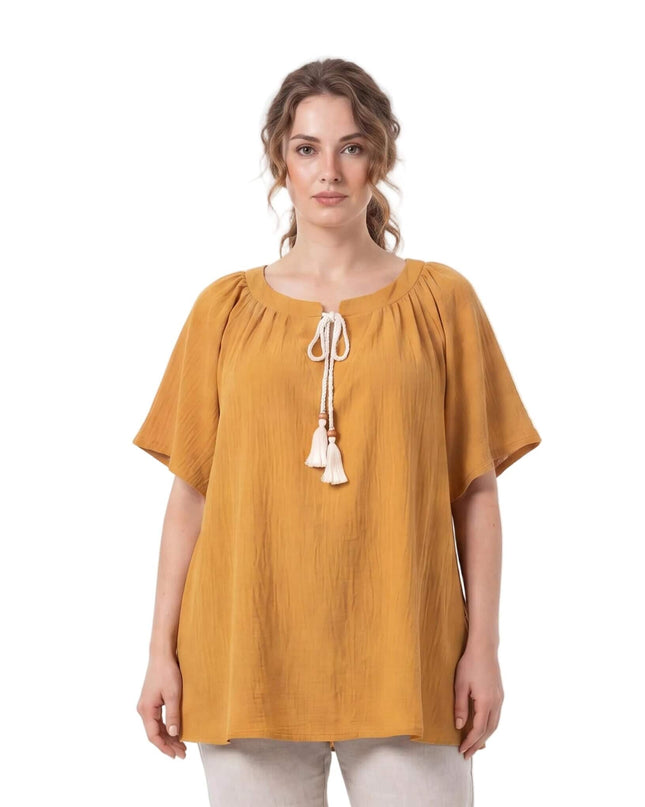 Γυναικεία τουνίκ plus size σε κίτρινο της μουστάρδας, με λευκά κορδόνια και φούντες στη λαιμόκοψη. Μπροστινή όψη σε λευκό φόντο.