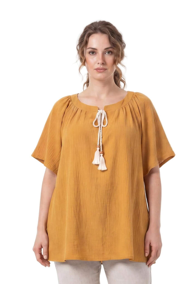 Γυναικεία τουνίκ plus size σε κίτρινο της μουστάρδας, με λευκά κορδόνια και φούντες στη λαιμόκοψη. Μπροστινή όψη σε λευκό φόντο.