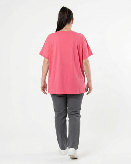 Πίσω όψη της κοραλί καλοκαιρινής τουνίκ σε μεγάλα μεγέθη. Άνετη εφαρμογή με κοντά μανίκια, φορεμένη από μοντέλο σε λευκό φόντο.