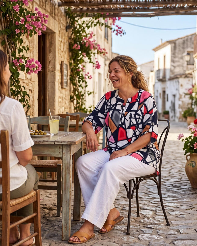 Γυναικεία πολύχρωμη πουκαμίσα τουνίκ με γεωμετρικό σχέδιο σε μεγάλα μεγέθη, φορεμένη σε ολόσωμη λήψη σε παραδοσιακό εξωτερικό χώρο.