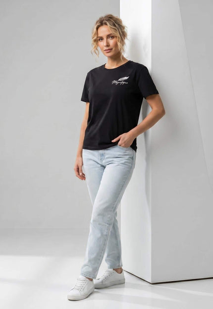 Ολόσωμη λήψη με μαύρο βαμβακερό γυναικείο t-shirt σε μεγάλα μεγέθη. Διακρίνεται η στρογγυλή λαιμόκοψη και η διακριτική λευκή στάμπα στο στήθος.