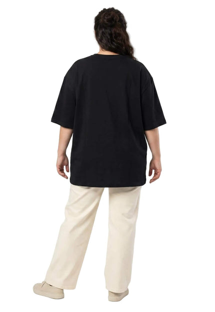 Πίσω όψη του κλασικού μαύρου βαμβακερού t-shirt σε μεγάλα μεγέθη. Ολόσωμη λήψη σε λευκό φόντο που δείχνει την άνετη γραμμή και τους ριχτούς ώμους.
