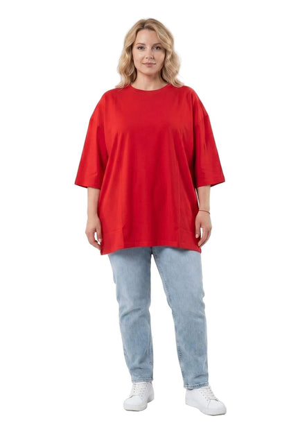 Ολόσωμη λήψη: Κόκκινο βαμβακερό t-shirt σε μεγάλα μεγέθη, με στρογγυλή λαιμόκοψη και φαρδιά ίσια γραμμή, συνδυασμένο με ανοιχτόχρωμο τζιν παντελόνι.
