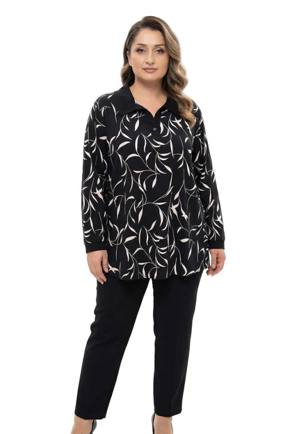 Κομψή γυναικεία τουνίκ plus size με εντυπωσιακό αφηρημένο print, μαύρο γιακά και μανσέτες, φορεμένη με μαύρο παντελόνι σε ολόσωμη λήψη.
