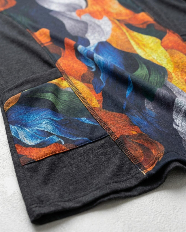 Κοντινή λήψη που αναδεικνύει την υφή και το αφηρημένο σχέδιο με φύλλα σε κομψή γυναικεία τουνίκ μεγάλα μεγέθη, εστιάζοντας στις ραφές και τα χρώματα.