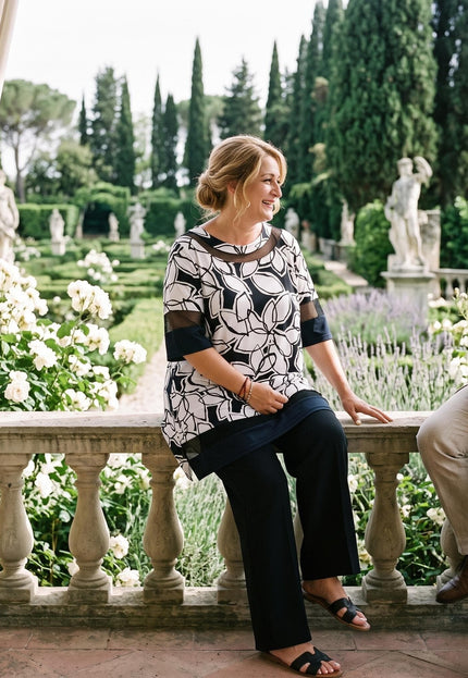 Γυναικεία τουνίκ plus size με ασπρόμαυρο μοτίβο και άνετη εφαρμογή, σε ολόσωμη λήψη σε εξωτερικό χώρο.