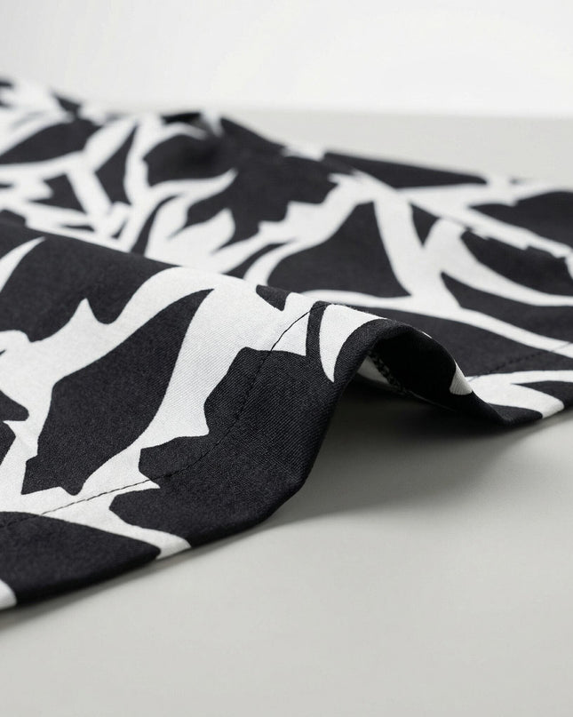 Κοντινή λεπτομέρεια στο τελείωμα και το ύφασμα από ασπρόμαυρο γυναικείο σακάκι χωρίς κούμπωμα σε μεγάλα μεγέθη, με μοντέρνο αφηρημένο σχέδιο.