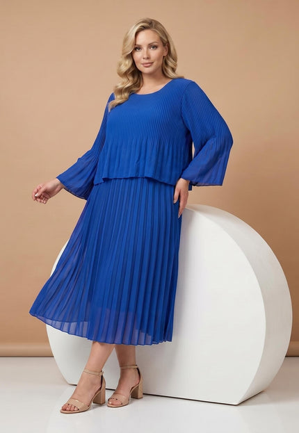 Κομψό επίσημο πλισέ φόρεμα plus size σε εντυπωσιακό μπλε ρουά χρώμα. Ολόσωμη λήψη που αναδεικνύει τα αέρινα μανίκια 3/4 και το σχέδιο με επίπεδα.