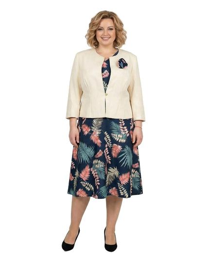 Κομψό γυναικείο ταγιέρ σε μεγάλα μεγέθη με μπεζ σακάκι και φλοράλ φόρεμα σε μπλε αποχρώσεις, σε ολόσωμη λήψη με λευκό φόντο.