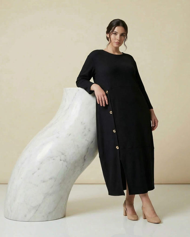 Ολόσωμη λήψη: Κομψό μαύρο επίσημο εβαζέ φόρεμα σε μεγάλα μεγέθη, με ριμπ ύφανση, 7/8 μανίκια και διακοσμητικά χρυσά κουμπιά στο πλάι.