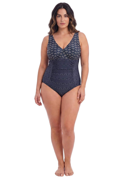 Κομψό πράσινο ολόσωμο μαγιό plus size με V-ντεκολτέ, σούρες και γεωμετρικό print στο επάνω μέρος, σε λευκό φόντο.