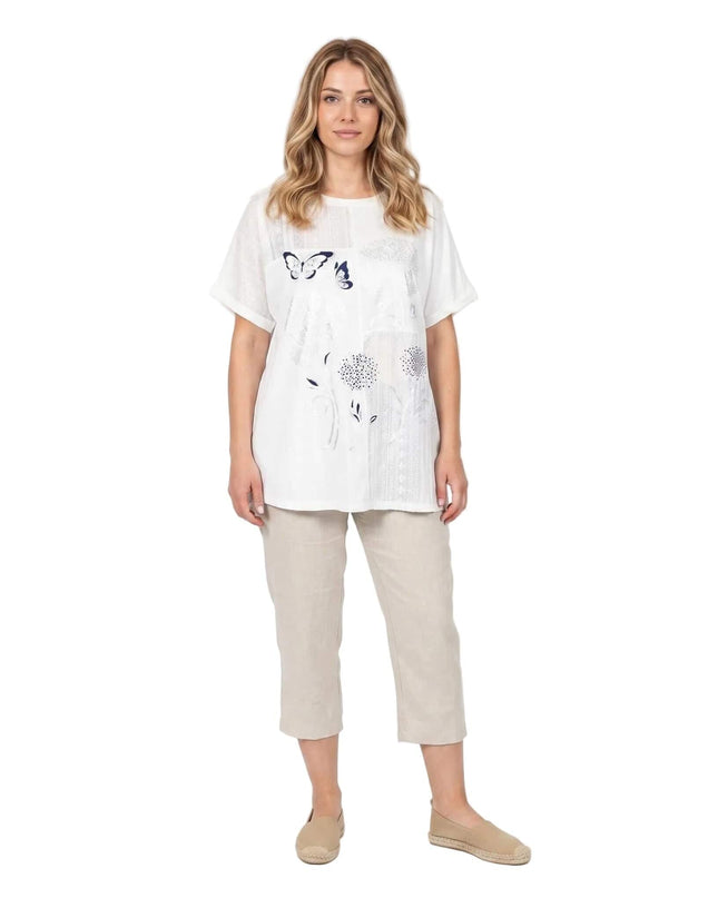 Λευκή βαμβακερή τουνίκ plus size με φλοράλ απλικέ. Ολόσωμη λήψη από μπροστά σε λευκό φόντο, με κοντά μανίκια και στρογγυλή λαιμόκοψη.