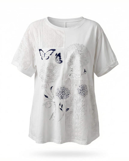 Λευκή βαμβακερή τουνίκ plus size, μπροστινή όψη σε λευκό φόντο. Διακρίνονται τα εντυπωσιακά φλοράλ απλικέ και τα πάνελ δαντέλας.