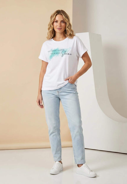 Λευκό βαμβακερό t-shirt plus size με τιρκουάζ στάμπα, σε ολόσωμη λήψη. Το μοντέλο το συνδυάζει με ανοιχτόχρωμο τζιν.