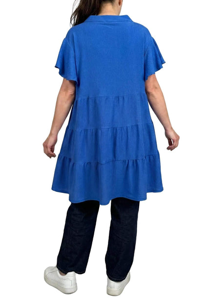 Πίσω όψη της μακριάς αέρινης μπλε τουνίκ plus size, όπου διακρίνεται ο πολυεπίπεδος σχεδιασμός σε γραμμή Α και τα κοντά μανίκια.