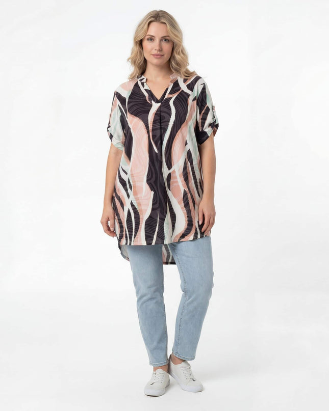 Γυναικεία μακριά καλοκαιρινή τουνίκ plus size με πολύχρωμο κυματιστό μοτίβο. Ολόσωμη λήψη μπροστά σε λευκό φόντο, αναδεικνύοντας τη λαιμόκοψη V.