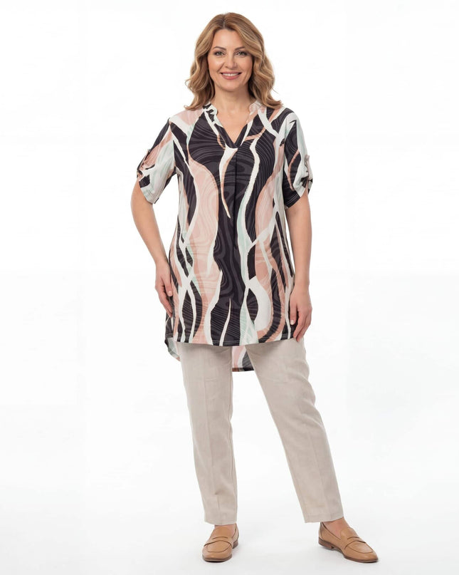 Ολόσωμη λήψη μπροστά, γυναίκα φοράει τη μακριά ασύμμετρη καλοκαιρινή τουνίκ plus size με το πολύχρωμο κυματιστό μοτίβο σε λευκό φόντο.