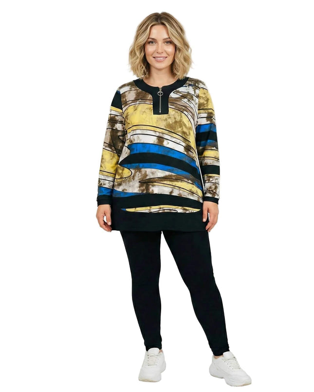 Μακριά εμπριμέ τουνίκ σε μεγάλα μεγέθη, με φερμουάρ στο ντεκολτέ και πολύχρωμο σχέδιο σε κίτρινο και μπλε. Ολόσωμη λήψη του ρούχου φορεμένου από μοντέλο.