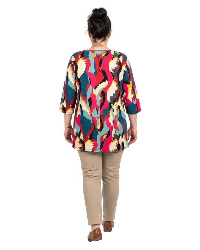 Πίσω όψη γυναικείας plus size τουνίκ με πολύχρωμο αφηρημένο μοτίβο. Ολόσωμη λήψη μοντέλου με μπεζ παντελόνι σε λευκό φόντο.