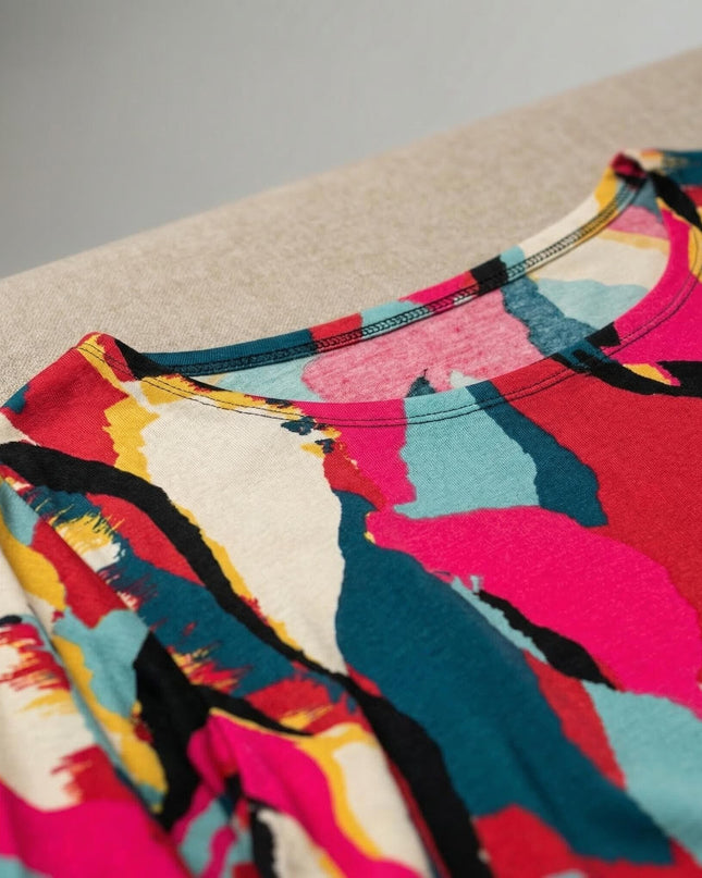 Κοντινή λεπτομέρεια της στρογγυλής λαιμόκοψης και του πολύχρωμου αφηρημένου μοτίβου σε αυτή την καλοκαιρινή plus size τουνίκ.