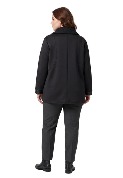 Πίσω όψη από μακριά μαύρη ζακέτα σε μεγάλα μεγέθη, συνδυασμένη με γκρι παντελόνι, σε ολόσωμη λήψη με λευκό φόντο.