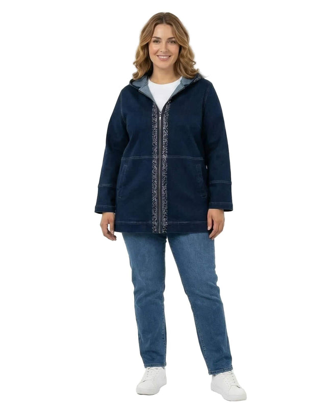 Ολόσωμη λήψη με γυναικείο μακρύ σκούρο μπλε τζιν μπουφάν σε μεγάλα μεγέθη. Διακρίνεται η κουκούλα και το φερμουάρ με διακοσμητικές πέτρες.