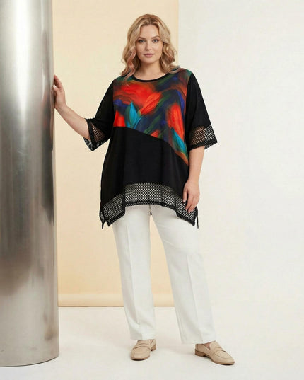 Ολόσωμη λήψη γυναίκας που φοράει μαύρη επίσημη τουνίκ σε μεγάλα μεγέθη με χρωματιστό μοτίβο μπροστά και δίχτυ στα μανίκια και το ασύμμετρο τελείωμα.
