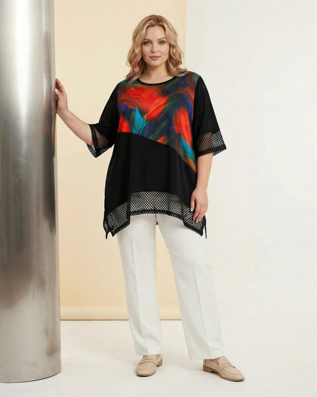 Ολόσωμη λήψη γυναίκας που φοράει μαύρη επίσημη τουνίκ σε μεγάλα μεγέθη με χρωματιστό μοτίβο μπροστά και δίχτυ στα μανίκια και το ασύμμετρο τελείωμα.