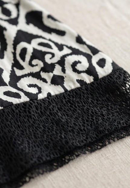 Κοντινή λεπτομέρεια από καλοκαιρινή τουνίκ σε μεγάλα μεγέθη, που αναδεικνύει το ασπρόμαυρο print και το κομψό μαύρο διχτυωτό ρέλι.