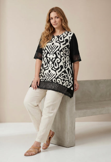 Ολόσωμη λήψη: Καλοκαιρινή τουνίκ σε μεγάλα μεγέθη με εντυπωσιακό ασπρόμαυρο print και μαύρα διχτυωτά στοιχεία στα μανίκια.