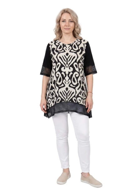 Ολόσωμη λήψη: γυναικεία μαύρη καλοκαιρινή τουνίκ σε μεγάλα μεγέθη, με ασπρόμαυρο αφηρημένο μοτίβο μπροστά και διχτυωτές λεπτομέρειες.