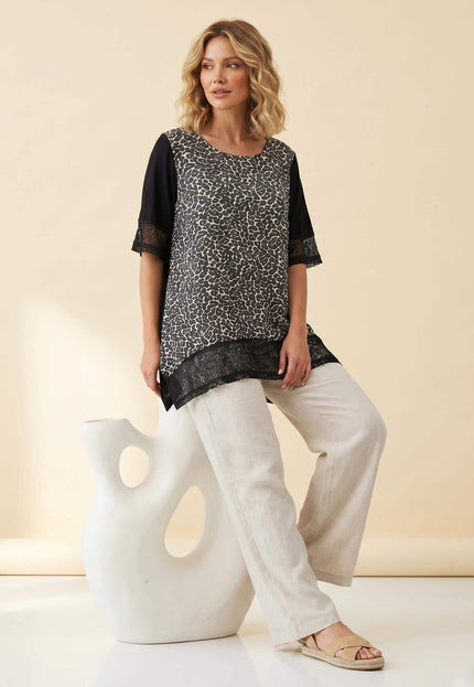 Ολόσωμη λήψη με καλοκαιρινή βαμβακερή τουνίκ plus size. Διαθέτει ασπρόμαυρο μοτίβο στο μπροστινό μέρος και κομψές λεπτομέρειες από δίχτυ στο τελείωμα.