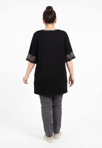 Πίσω όψη: Μαύρη καλοκαιρινή βαμβακερή τουνίκ plus size. Διακρίνεται η απλή μονόχρωμη πλάτη και οι λεπτομέρειες από δίχτυ στα τελειώματα των μανικιών.