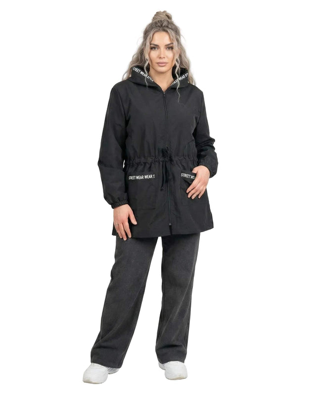 Μαύρο γυναικείο αντιανεμικό μπουφάν plus size με ρυθμιζόμενη μέση, κουκούλα και τσέπες με διακοσμητικά γράμματα, σε ολόσωμη λήψη.