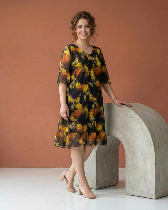 Ολόσωμη λήψη, μαύρο επίσημο σιφόν φόρεμα μεγάλα μεγέθη με κίτρινο αφηρημένο μοτίβο, μανίκια καμπάνα και βολάν στο τελείωμα.