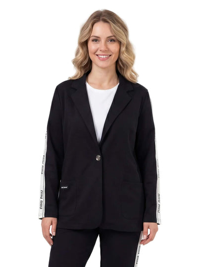 Μαύρο καθημερινό γυναικείο σετ σακάκι και παντελόνι σε μεγάλα μεγέθη, με λευκή ρίγα στα μανίκια και κλείσιμο με ένα κουμπί, σε μεσαίο πλάνο.