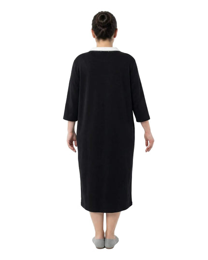 Πίσω όψη από μαύρο σπορ φόρεμα μεγάλα μεγέθη με ίσια γραμμή και μανίκια 7/8. Διακρίνεται η άνετη εφαρμογή στην πλάτη και το μήκος κάτω από το γόνατο σε λευκό φόντο.